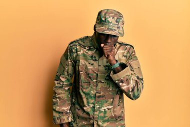 Afro-Amerikan üniformalı genç bir adam kendini kötü hissediyor ve soğuk algınlığı veya bronşitin belirtisi olarak öksürüyor. sağlık hizmeti kavramı. 