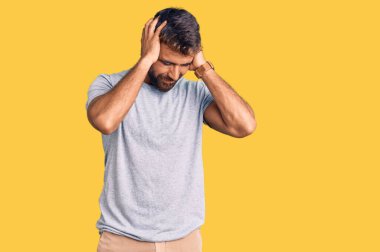 İspanyol asıllı genç adam gündelik giysiler giyiyor. Baş ağrısı çekiyor. Acı ve migren yüzünden çaresiz ve stresli. Eller başının üstünde.. 