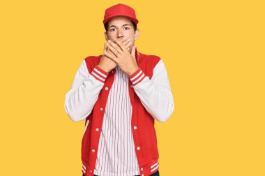 Beyzbol üniforması giyen yakışıklı beyaz adam yanlışlıkla elleri ile ağzını kapatırken şok oldu. gizli kavram. 