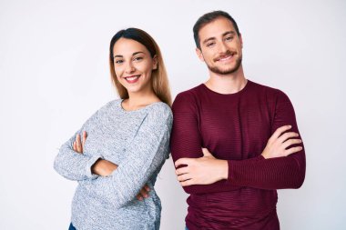 Gündelik kıyafetler giyen, kollarını kavuşturup kameraya bakan mutlu yüzlü güzel bir çift. pozitif kişi. 