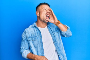 Sıradan bir kot ceket giyen yakışıklı kaslı adam el ele tutuşup bağırıyor ve bağırıyordu. iletişim konsepti. 