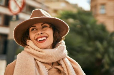 Şık giyinen genç İspanyol kadın şehirde dikiliyor..