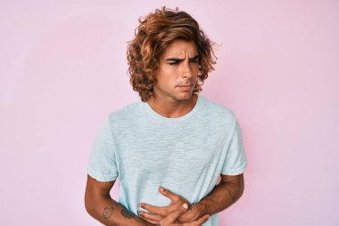 hazımsızlık, acı verici bir hastalık ve midesi kötü hissettiği için günlük giysiler giyen genç İspanyol bir adam. Ağrı kavramı. 