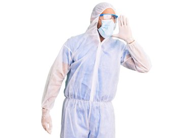 Doktor korumalı koronavirüs üniforması giyen genç İspanyol adam ve tıbbi maske bağırıyor ve ağızdan ağıza bağırıyor. iletişim konsepti. 