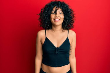 Kolsuz gömlekli, mutlu ve havalı bir gülümsemesi olan gündelik tarzda giyinen İspanyol bir kadın. şanslı kişi. 