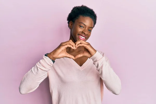 手でハートのシンボルの形をする愛に笑顔カジュアルな服を着ている若いアフリカ系アメリカ人の女の子 ロマンチックなコンセプト — ストック写真