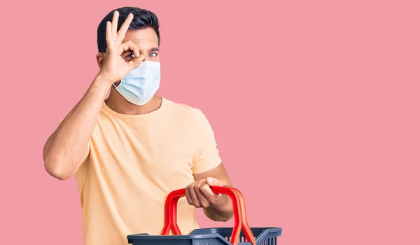 Ung Latinamerikan Man Bär Korg Och Medicinsk Mask Ler Glad — Stockfoto