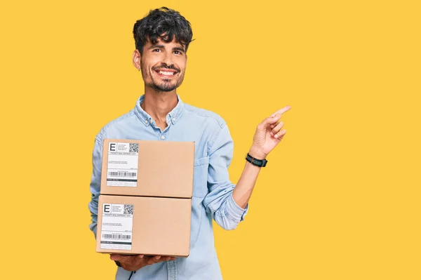 Jonge Spaanse Man Houdt Levering Pakket Glimlachend Gelukkig Wijzend Met — Stockfoto