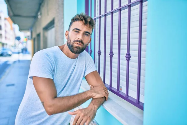 Şehrin duvarına yaslanmış, ciddi bir suratı olan genç bir İspanyol.