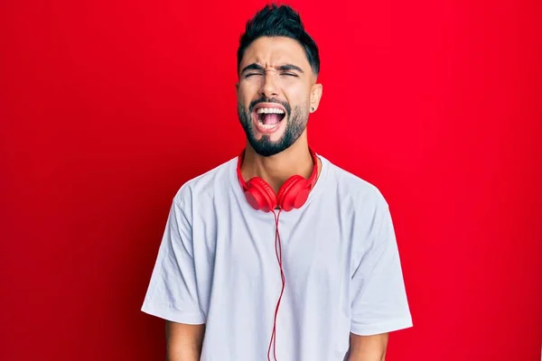 Young Man Beard Listening Music Using Headphones Angry Mad Screaming — Stock Photo, Image