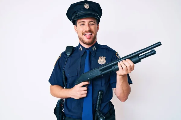 Young Caucasian Man Wearing Police Uniform Holding Shotgun Sticking Tongue — Stock Photo, Image