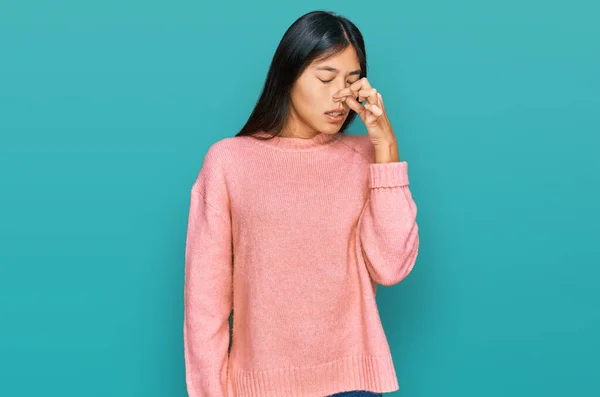 스웨터를 아름답고 아시아인 여인은 손가락을 수없는 악취가 역겨운 냄새를 맡았다 — 스톡 사진