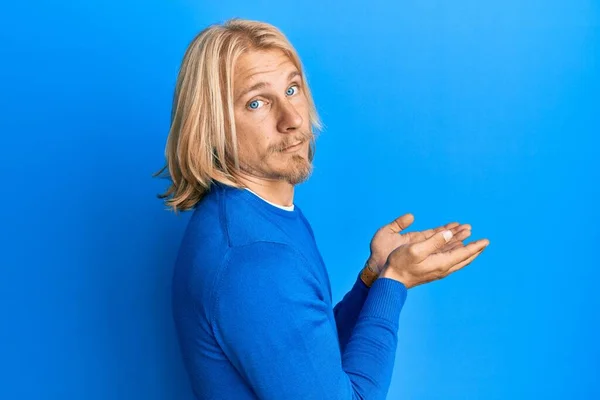 Caucasian Young Man Long Hair Presenting Open Palms Holding Something — Stock Photo, Image