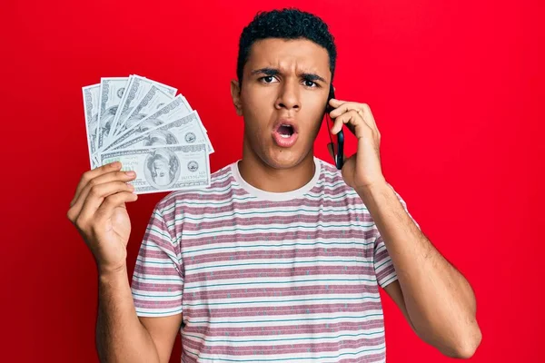 Hombre Árabe Joven Teniendo Conversación Hablando Teléfono Inteligente Sosteniendo Dólares —  Fotos de Stock