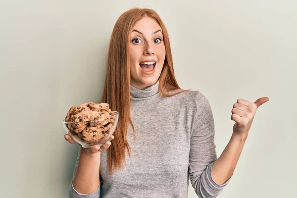 Joven Mujer Irlandesa Sosteniendo Tazón Con Galletas Chispas Chocolate Apuntando — Foto de Stock