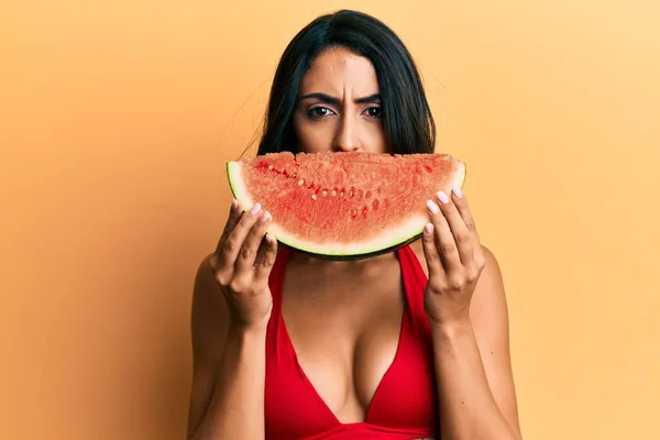 Schöne Hispanische Frau Legt Wassermelonenscheibe Als Lustiges Lächeln Skeptisch Und — Stockfoto
