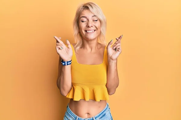 Jovencita Rubia Vistiendo Ropa Casual Haciendo Gestos Con Dedo Cruzados — Foto de Stock