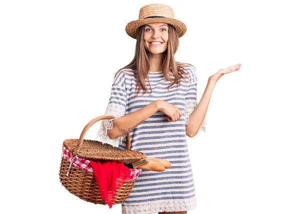 夏の帽子をかぶった美しい白人女性と幸せな笑顔で勝利を祝うパンとピクニックウィッカーバスケットを保持し 上げ手で勝者の式 — ストック写真