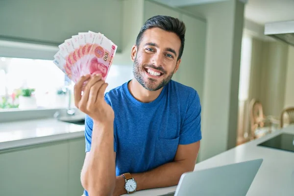 若い男は幸せな家庭で中国元紙幣を保持笑みを浮かべて — ストック写真