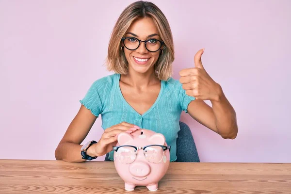 Beautiful Caucasian Woman Holding Piggy Bank Glasses Smiling Happy Positive — Stock Photo, Image