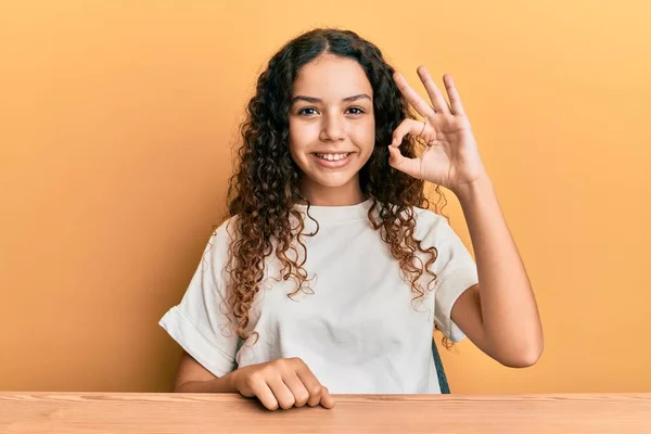 Tonåring Hispanic Flicka Bär Casual Kläder Sitter Bordet Ler Positivt — Stockfoto