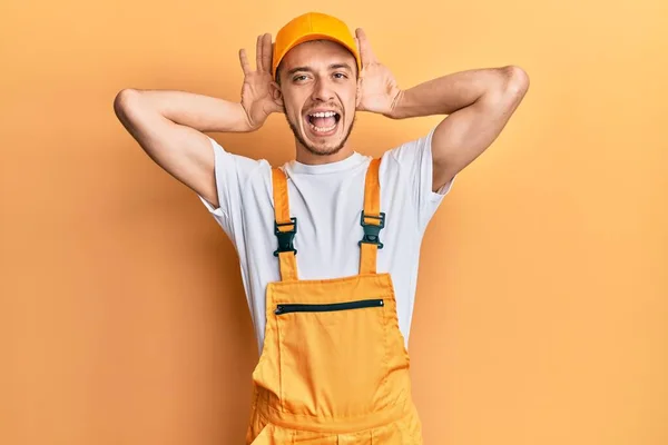 Hispanic Young Man Wearing Handyman Uniform Smiling Cheerful Playing Peek — Stock Photo, Image