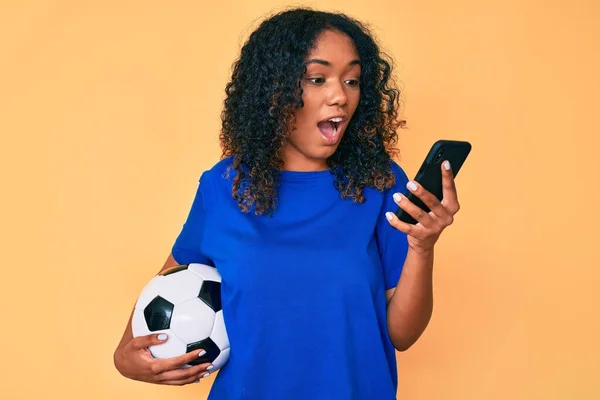 Giovane Donna Afroamericana Che Tiene Palla Calcio Guardando Smartphone Spaventato — Foto Stock