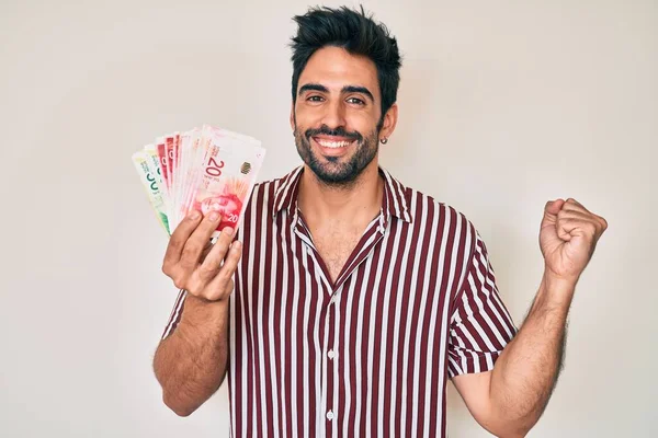 Handsome Hispanic Man Beard Holding Israel Shekels Screaming Proud Celebrating — 图库照片