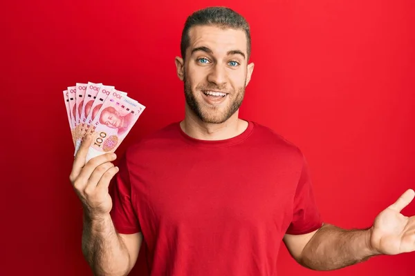 Joven Hombre Caucásico Sosteniendo Yuan Billetes Chinos Celebrando Logro Con —  Fotos de Stock