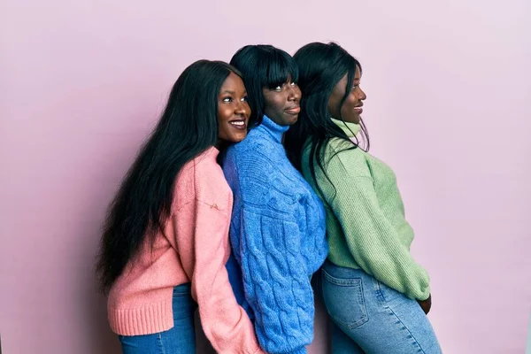 3人の若いアフリカ系アメリカ人の友人は ウールの冬のセーターを着て横に見て 自然な顔と自信を持って笑顔でプロファイルポーズをリラックス — ストック写真