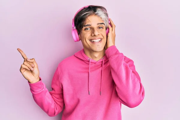 Jovem Hispânico Ouvindo Música Usando Fones Ouvido Sorrindo Feliz Apontando — Fotografia de Stock