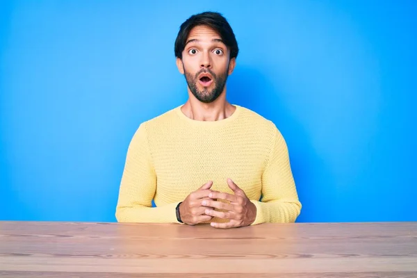Handsome Hispanic Man Wearing Casual Sweater Sitting Table Scared Amazed — Stok fotoğraf