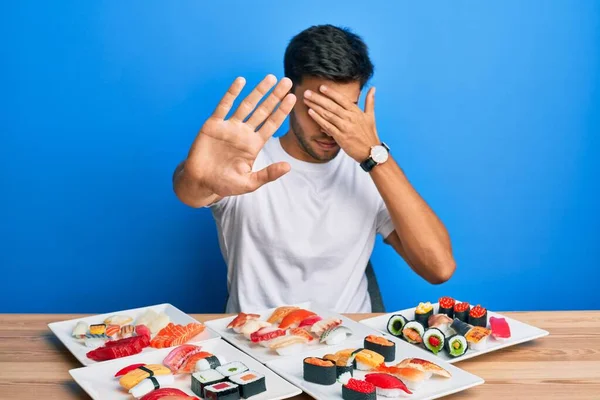 Young Handsome Man Eating Sushi Sitting Table Covering Eyes Hands — Stock Photo, Image