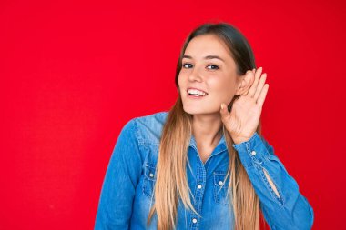 Kafkasyalı güzel bir kadın, sıradan bir kot gömlek giyer, kulağı kulağında gülümser, dedikoduları ve dedikoduları dinler. Sağırlık kavramı. 