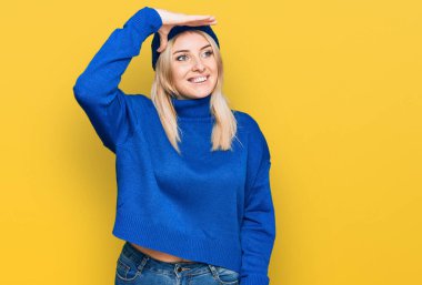 Kafkasyalı genç bir kadın yün kazak ve kep giyiyor. Çok mutlu ve tebessüm ediyor. arama kavramı. 