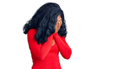 Güzel afro-amerikan kadın günlük kıyafetler giyiyor üzgün bir ifade takınıyor ellerle yüzünü kapatıyor ve ağlıyor. depresyon kavramı. 