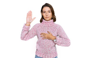 Young caucasian girl wearing wool winter sweater swearing with hand on chest and open palm, making a loyalty promise oath 