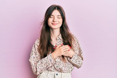 Zarif kıyafetler giyen, göğsünde elleri kapalı, yüzünde minnet dolu bir jest olan güzel beyaz bir kız. sağlık kavramı. 