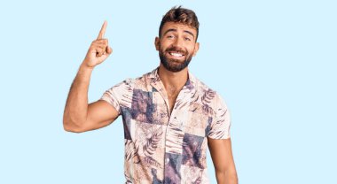 Yaz kıyafetleri giymiş genç bir İspanyol başarılı bir fikri işaret ediyor. Heyecanlı ve mutlu. Bir numara.. 