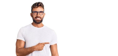 Gündelik kıyafet ve gözlük takan İspanyol genç adam endişeli ve gergin bir şekilde işaret ediyor. 