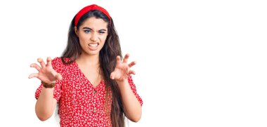 Yazlık elbise giyen esmer kız komik gülüyor kedi gibi pençe hareketi yapıyor, agresif ve seksi bir ifade. 