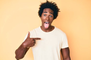 Yakışıklı, Afro saçlı, kendini gösteren, komik bir ifadeyle dilini dışarı çıkaran Afro Amerikalı bir adam.. 