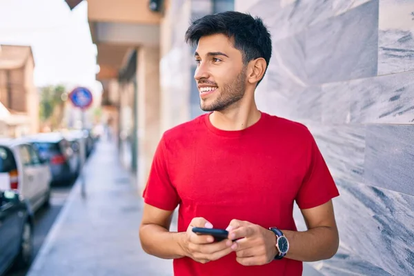 Joven Latino Sonriendo Feliz Usando Smartphone Caminando Por Ciudad —  Fotos de Stock