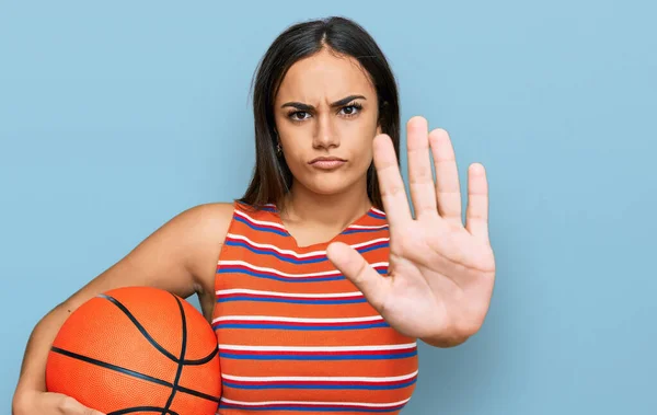 Joven Morena Sosteniendo Pelota Baloncesto Con Mano Abierta Haciendo Stop —  Fotos de Stock