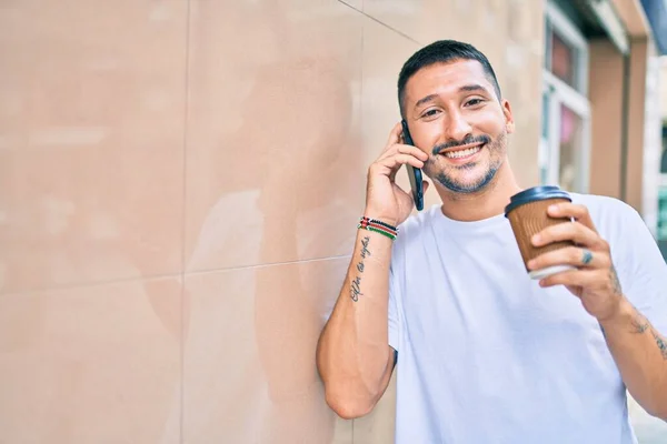 Giovane Uomo Ispanico Parlando Sullo Smartphone Bevendo Caffè Appoggiato Muro — Foto Stock