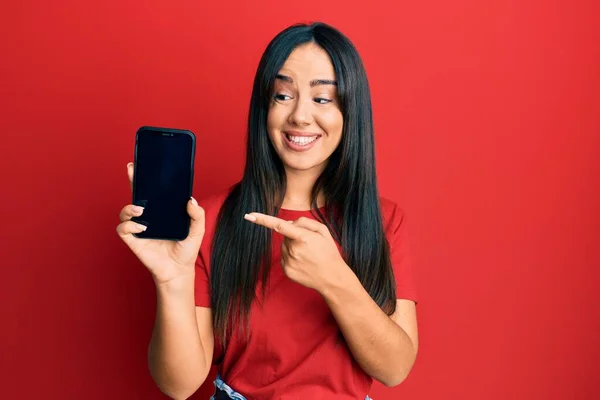 Młoda Piękna Latynoska Dziewczyna Trzyma Smartfon Pokazując Ekran Uśmiechnięty Szczęśliwy — Zdjęcie stockowe