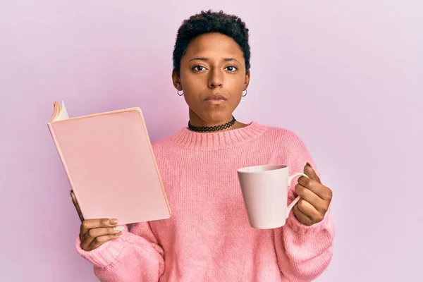 Chica Afroamericana Joven Leyendo Libro Bebiendo Una Taza Café Relajado —  Fotos de Stock