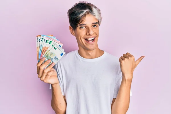 Молодий Іспаномовний Чоловік Тримає Банкноти Євро Вказуючи Великий Палець Сторону — стокове фото