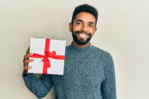 Snygg Latinamerikansk Man Med Skägg Håller Gåva Ser Positiv Och — Stockfoto