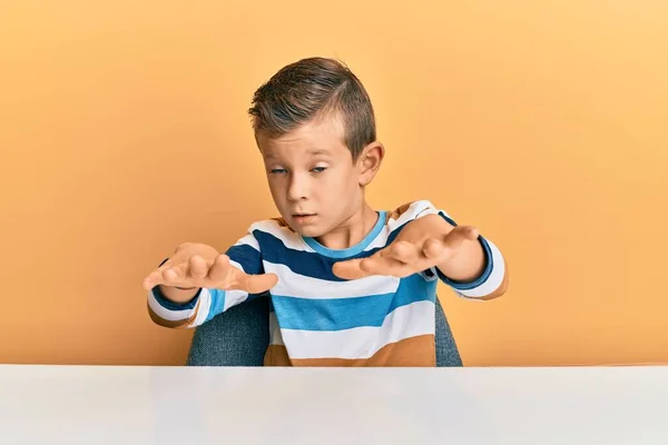 Adorable Niño Caucásico Con Ropa Casual Sentado Mesa Haciendo Gesto — Foto de Stock